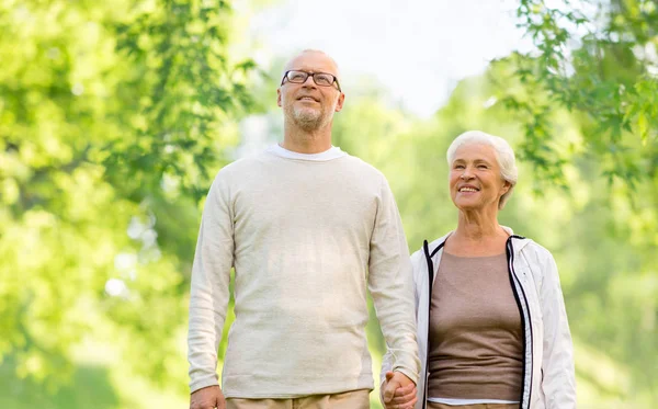 Happy senior couple over green natural background — Stock Photo, Image