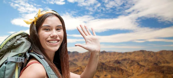 Donna sorridente con zaino sulle montagne — Foto Stock