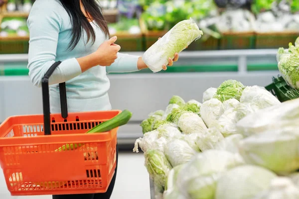 Woman with basket and chinese cabbage at grocery — Stock Photo, Image