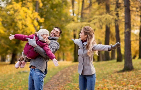 Família feliz jogando no parque de outono — Fotografia de Stock