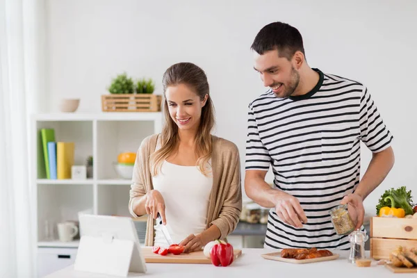 Щаслива пара з планшетним ПК готує їжу вдома — стокове фото