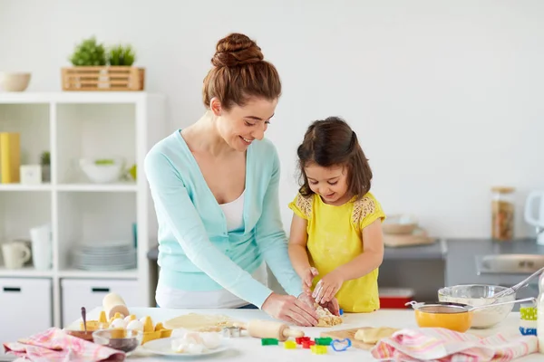 Glückliche Mutter und Tochter backen Plätzchen zu Hause — Stockfoto