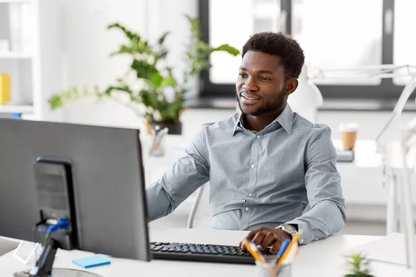 Empresario africano con ordenador en la oficina — Foto de Stock