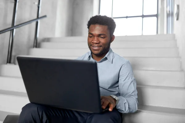 Empresário afro-americano com laptop no escritório — Fotografia de Stock