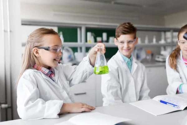 Crianças com tubos de ensaio que estudam química na escola — Fotografia de Stock