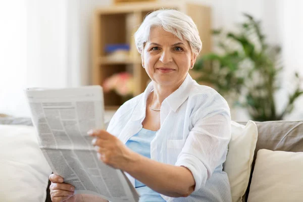 Mulher sênior ler jornal em casa — Fotografia de Stock