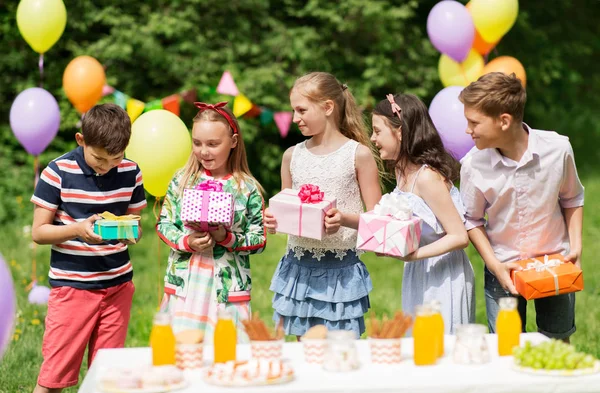Glada barn med gåvor på födelsedagsfest på sommaren — Stockfoto