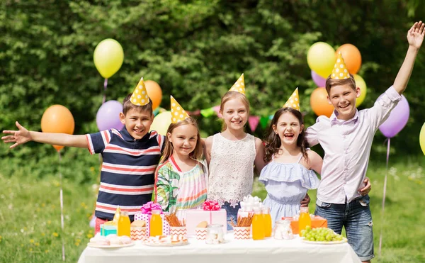 Счастливые дети на дне рождения в летнем саду — стоковое фото
