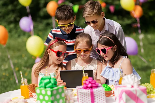 Niños felices con la PC tableta en la fiesta de cumpleaños —  Fotos de Stock