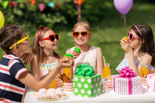 Barnen äta cupcakes på födelsedagsfest på sommaren — Stockfoto