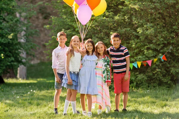 Crianças felizes com balões na festa de aniversário de verão — Fotografia de Stock