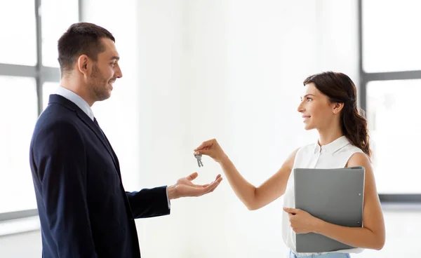 Agent immobilier donnant la clé au client au nouveau bureau — Photo