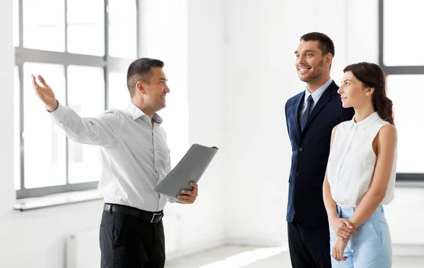 Realtor with folder showing customers new office — Stock Photo, Image