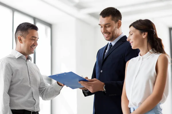 Realtor showing contract document to customers — Stock Photo, Image