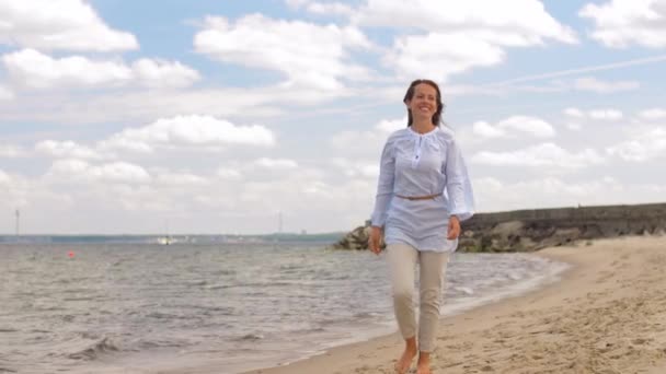 Felice donna sorridente passeggiando lungo la spiaggia estiva — Video Stock