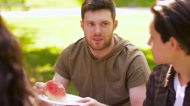 Happy vrienden eten watermeloen op zomerpicknick — Stockvideo