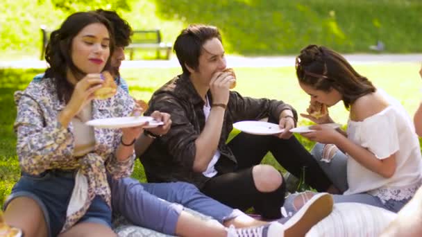 Happy vrienden eten broodjes bij zomerpicknick — Stockvideo