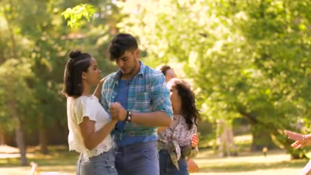 Happy vrienden dansen op zomer feest in het park — Stockvideo