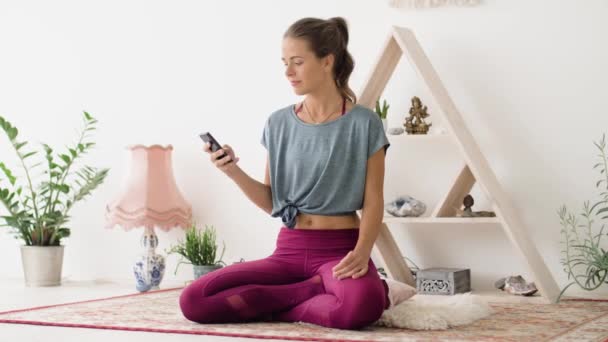 Woman with smartphone meditating at yoga studio — Stock Video