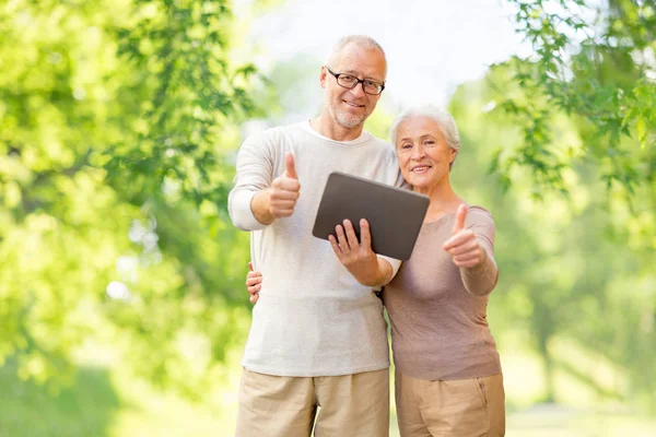 Senior couple with tablet pc showing thumbs up — Stock Photo, Image