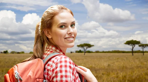 Gelukkige vrouw met rugzak over Afrikaanse savanne — Stockfoto