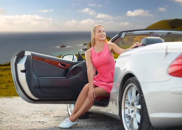 Woman posing in convertible car over big sur coast — Stock Photo, Image