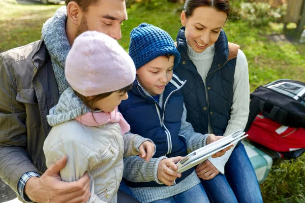 Familie sitzt mit Tablet-PC auf Bank im Camp — Stockfoto