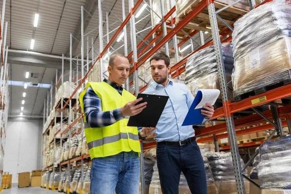 Werknemer en zakenman met Klembord in magazijn — Stockfoto