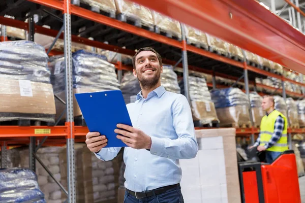 Glücklicher Geschäftsmann mit Klemmbrett im Lager — Stockfoto