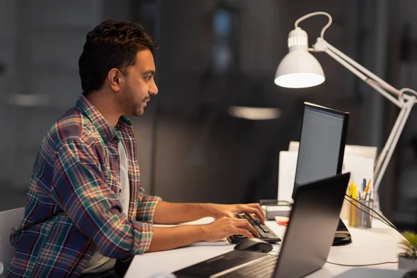 Homme créatif avec ordinateur travaillant au bureau de nuit — Photo