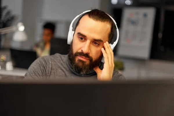 Ofiste çalışan kulaklıklar ile yaratıcı adam — Stok fotoğraf