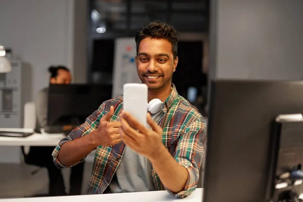 Hombre con smartphone que tiene videollamada en la oficina —  Fotos de Stock