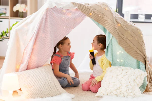 Meninas com luz da tocha na tenda crianças em casa — Fotografia de Stock
