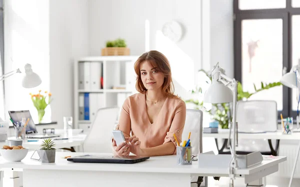 Femme d'affaires avec smartphone travaillant au bureau — Photo