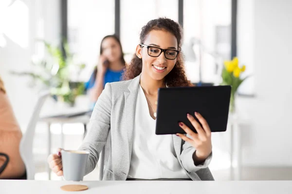 Бізнес-леді з планшетним ПК і кавою в офісі — стокове фото
