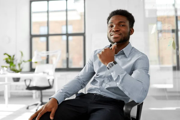 Homme d'affaires africain assis sur une chaise de bureau — Photo