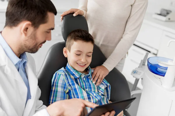 Dentista mostrando tableta PC a niño en la clínica dental — Foto de Stock