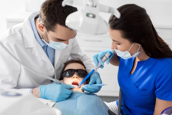 Стоматолог, лечащий детские зубы в стоматологической клинике — стоковое фото