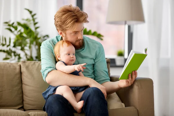 Far läser bok för baby dotter hemma — Stockfoto