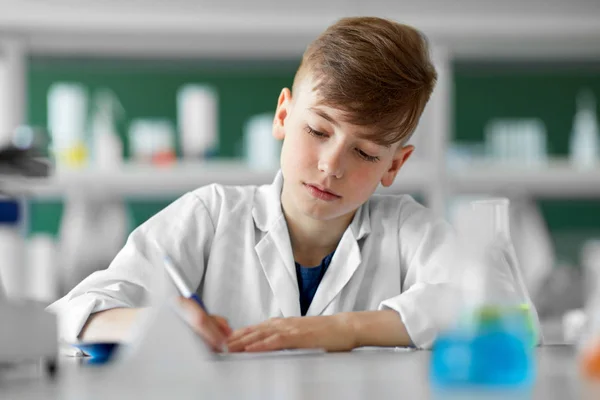 Chico con cuaderno estudiando biología en la escuela — Foto de Stock