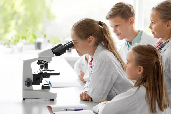 Kids or students with microscope biology at school — Stock Photo, Image