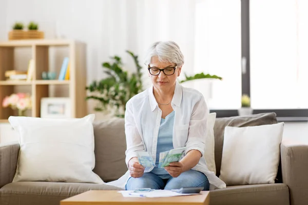 Senior woman counting money at home — Stock Photo, Image