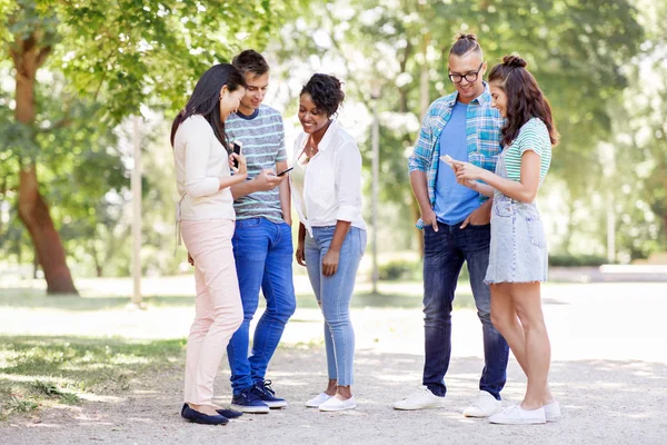 Grupp av glada vänner med smartphone utomhus — Stockfoto