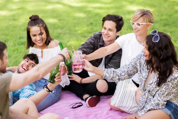 Přátel, cinkání, nápoje na pikniku v parku léta — Stock fotografie