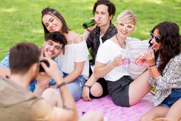 Friends photographing at picnic in summer park — Stock Photo, Image