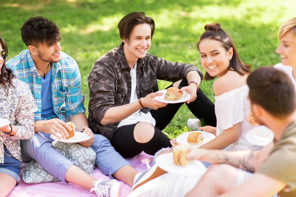 Happy přátelé jíst sendviče na letní piknik — Stock fotografie