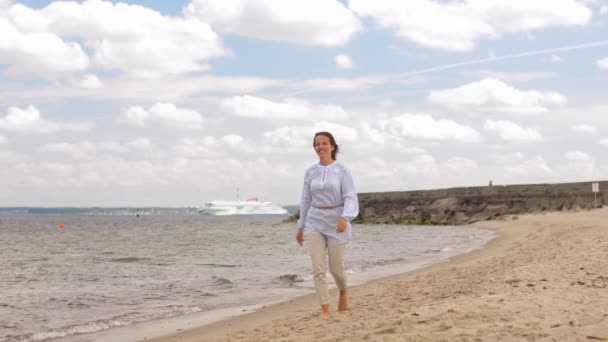 Lyckligt leende kvinna promenader längs sommar strand — Stockvideo