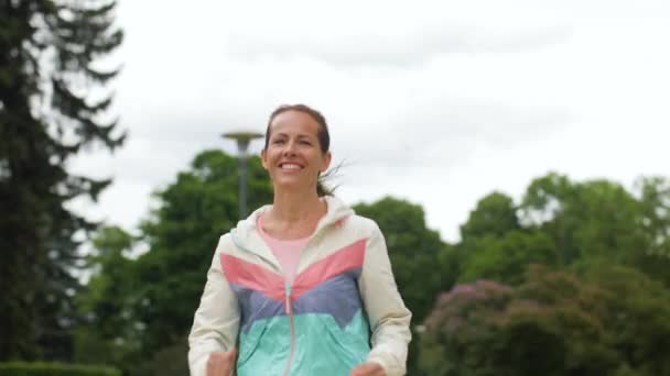 Sonriente mujer corriendo por el parque — Vídeos de Stock