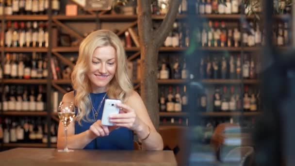 Woman with smartphone at wine bar or restaurant — Stock Video