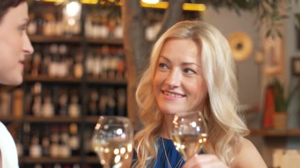 Счастливые женщины пьют вино в баре или ресторане — стоковое видео